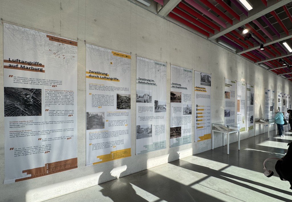 Gro&szlig;formatige Stoffbanner der Ausstellung im Sonnenlicht